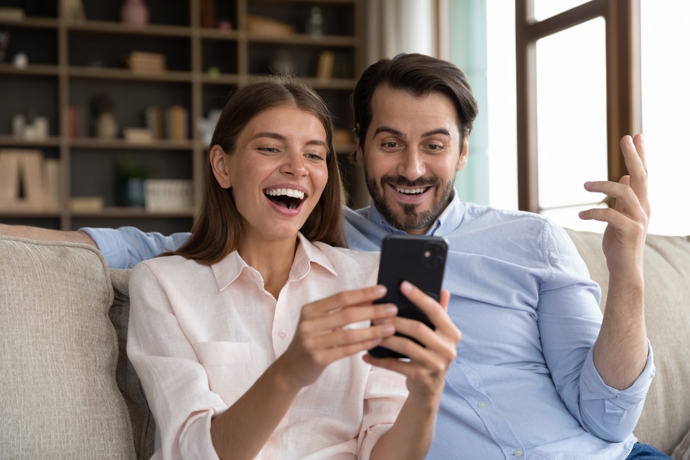 Overjoyed,Young,Family,Couple,Looking,At,Telephone,Screen,,Feeling,Excited Perceber qual e a estrutura do bonus de registro